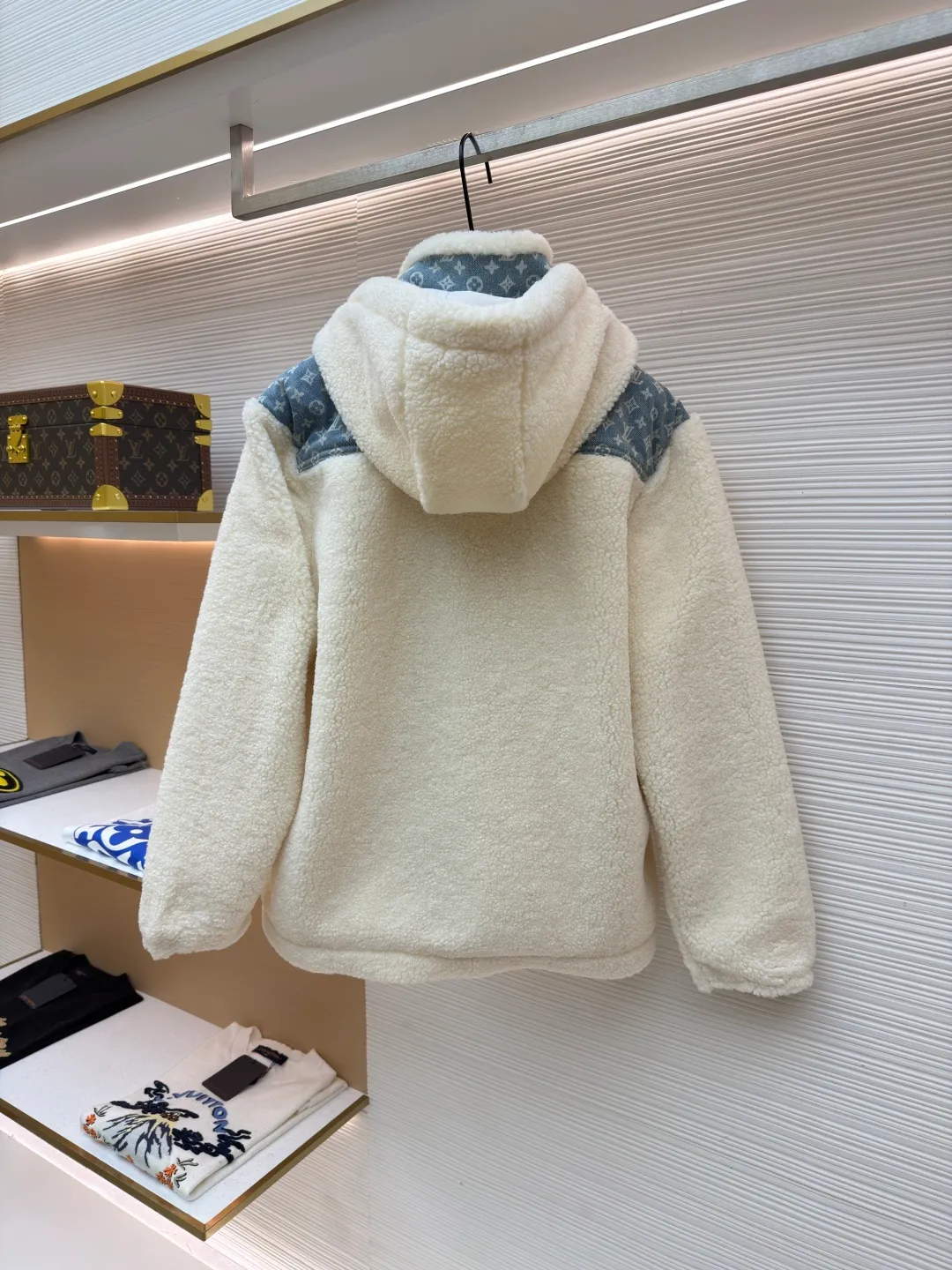 LOUIS VUITTON Letter jacquard splicing lamb wool ski hooded jacket ●Original version: purchased and developed by 26909 ●Item number: 1682241-C35 ●Fabric: lamb wool fabric ●Technology: jacquard production ●Color: off-white ●Version: fitted version ●Weight: about 1245 grams ●Size: 34-36-38-40-42-44 ●Description: The main body of this lamb wool spliced denim jacket is made of imported imitation lamb wool fabric, which has been processed by carding and shaping processes. The wool feels fluffy and soft and is not easy to shed and pill. The fabric has a uniform weight and has both warmth retention and breathability. The neckline, placket and chest pockets are spliced ​​with classic presbyopic denim. The denim is enzymatically washed to create a natural aged texture. The presbyopic pattern is embossed, making the texture three-dimensional and not easy to fall off. The body adopts a loose hooded fit, with a built-in shaping lining on the brim and an adjustable drawstring design; a custom metal zipper is used at the placket, and the chain teeth are gold-plated for smooth pulling and anti-oxidation. The edges of the pockets are reinforced with double stitching, and the splicing of lambswool and denim is made by hand caulking. The stitching is fine and smooth. Every detail is strictly controlled, showing the craftsmanship and quality of high-end clothing. The overall wiring is straight and delicate, the fabric is comfortable and soft, and the color is consistent without color difference. It can be matched with the same style to create a fashionable look and control various occasions. Customized accessories, complete with three standards, same style for men and women!